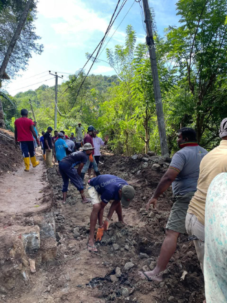 Men repairing a damaged walking path in the village