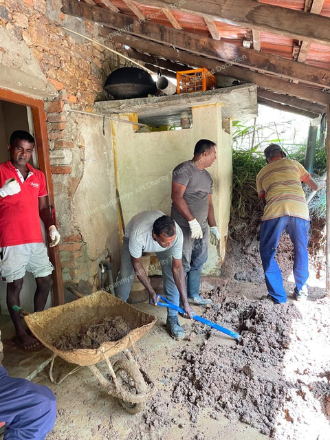 Interior home repairs with volunteers clearing mud from the floor