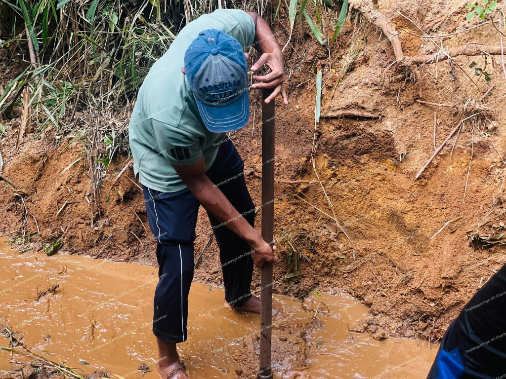 Resident digging manually through thick mud