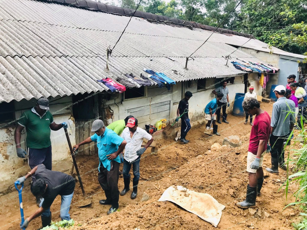 School or community building covered in mud with volunteers cleaning